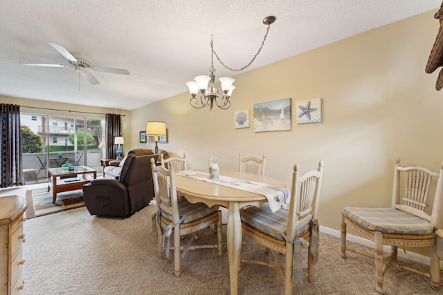 dining area with ceiling fan with notable chandelier, a textured ceiling, and light colored carpet