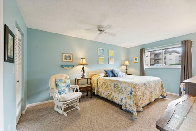 carpeted bedroom with ceiling fan and a textured ceiling