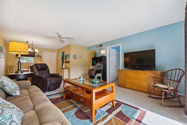 living room featuring carpet and ceiling fan with notable chandelier