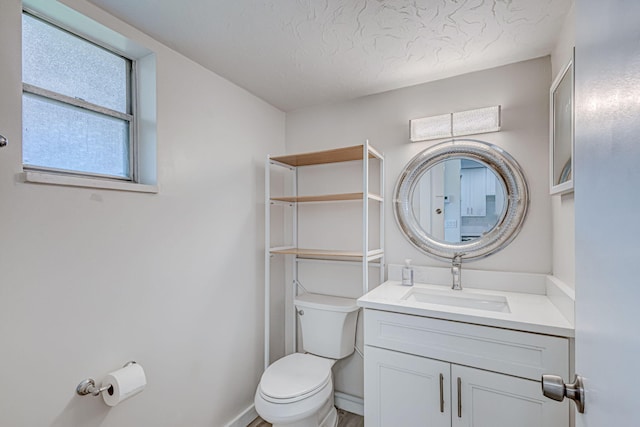 bathroom featuring vanity, a textured ceiling, and toilet