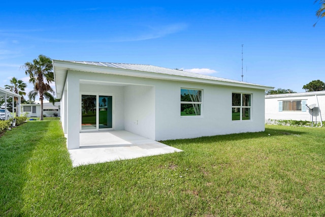 rear view of house featuring a yard and a patio