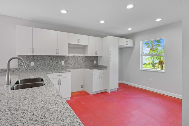 kitchen with backsplash, sink, and white cabinets