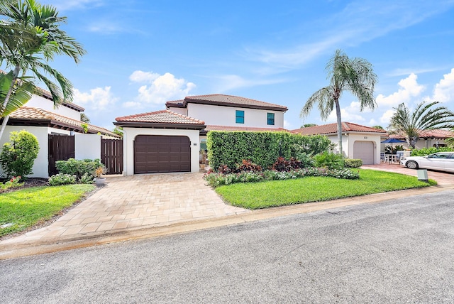 mediterranean / spanish house with a front lawn and a garage