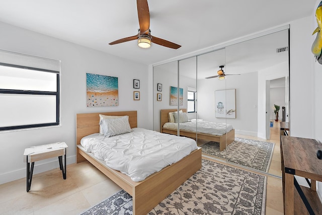 tiled bedroom with multiple windows, a closet, and ceiling fan