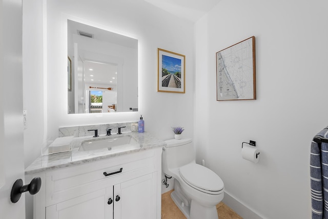 bathroom featuring tile patterned flooring, vanity, and toilet