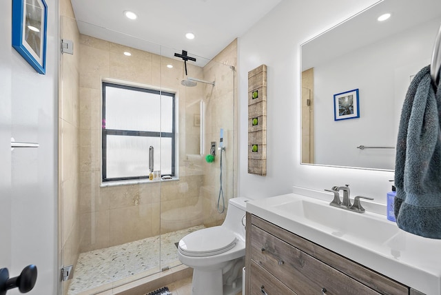 bathroom with vanity, toilet, and a shower with door