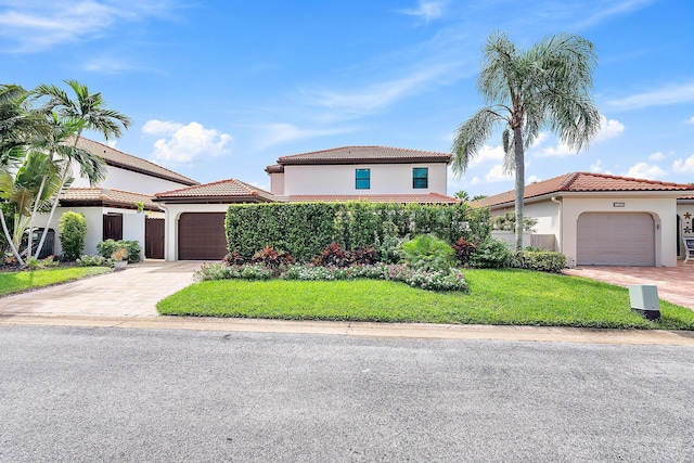 1484 Via Del Sol, Jupiter, FL 33477 - mediterranean / spanish-style home with an attached garage, driveway, stucco siding, a front lawn, and a tiled roof