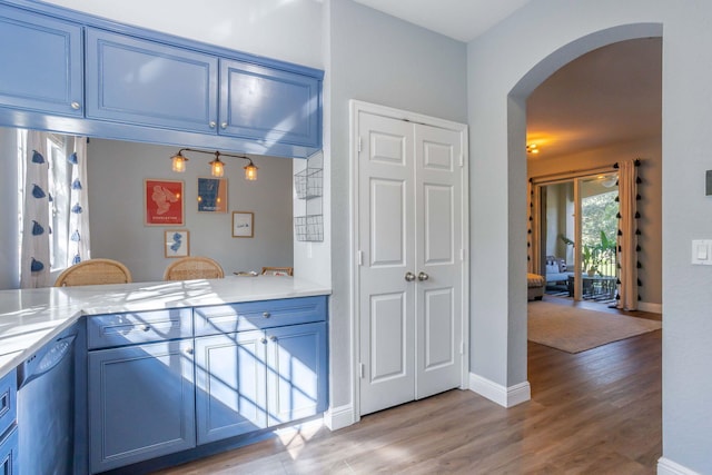 kitchen with dishwasher, light hardwood / wood-style flooring, and blue cabinets