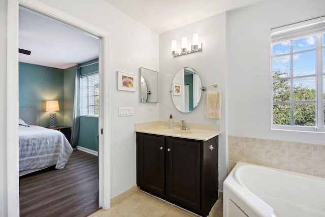 bathroom featuring vanity, a tub to relax in, a wealth of natural light, and wood-type flooring