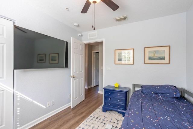 bedroom with dark hardwood / wood-style flooring and ceiling fan