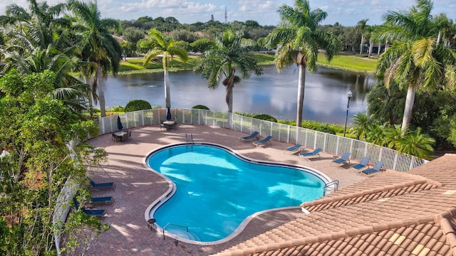 view of swimming pool featuring a water view and a patio area