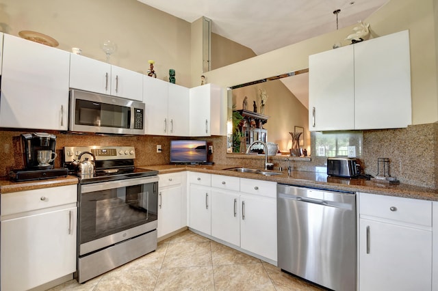 kitchen with stainless steel appliances, sink, light tile patterned floors, backsplash, and white cabinets