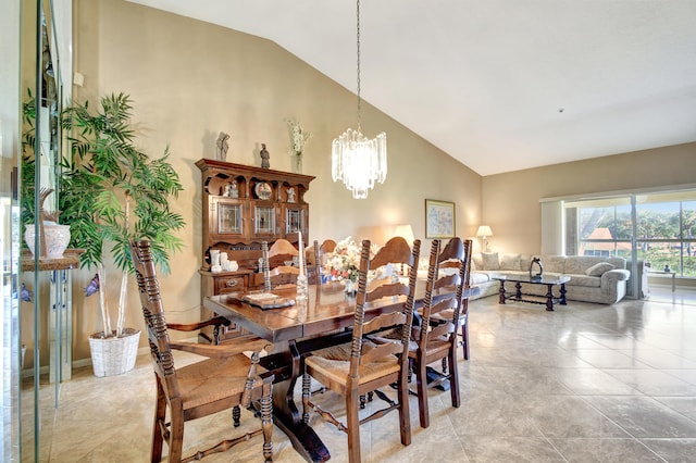 dining space featuring an inviting chandelier and high vaulted ceiling