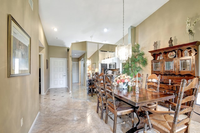 dining space with high vaulted ceiling and a notable chandelier