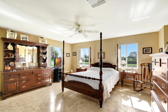 tiled bedroom featuring a textured ceiling and ceiling fan