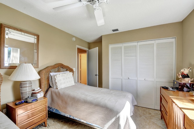 carpeted bedroom featuring ceiling fan and a closet