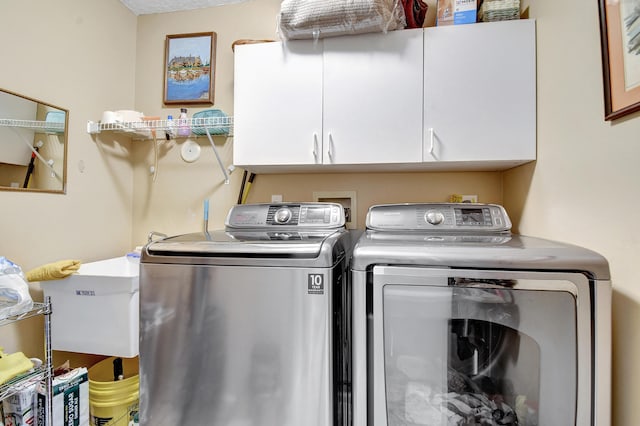 laundry area featuring cabinets, sink, and washing machine and clothes dryer