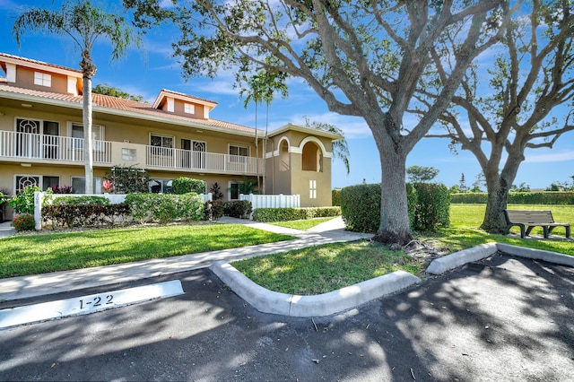 mediterranean / spanish-style home with a front lawn