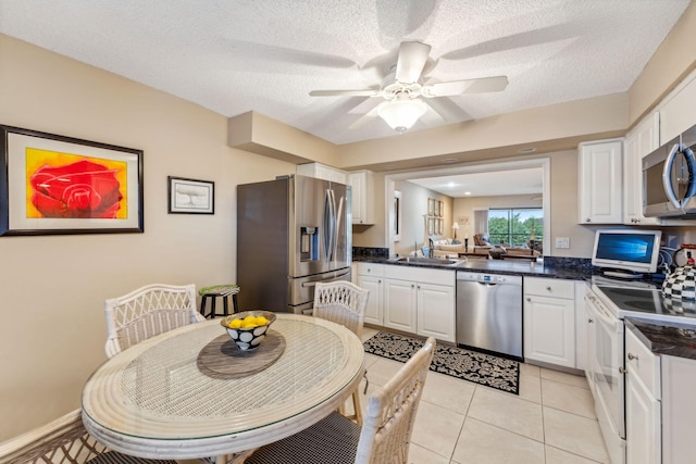 kitchen with white cabinets, a textured ceiling, and appliances with stainless steel finishes