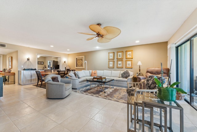 tiled living room featuring ceiling fan and a textured ceiling