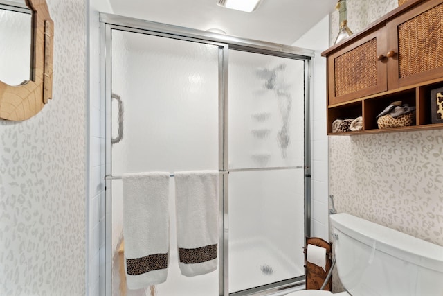 bathroom with toilet and a shower with shower door