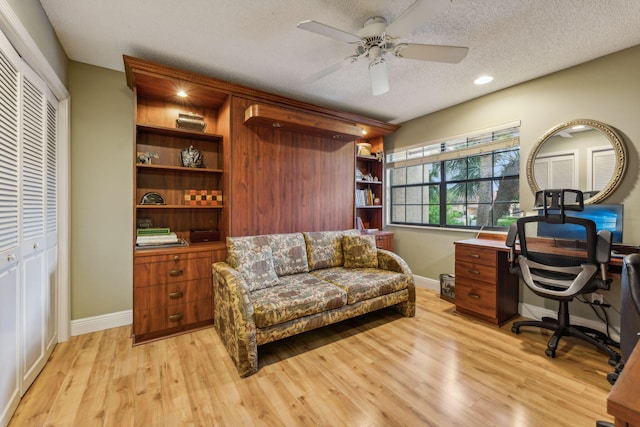 office space featuring ceiling fan, light hardwood / wood-style flooring, and a textured ceiling