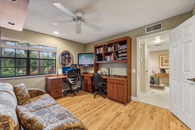 office featuring a textured ceiling, light hardwood / wood-style floors, and ceiling fan