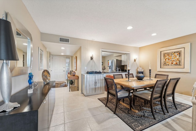 dining room featuring light tile patterned floors and a textured ceiling