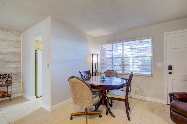 tiled dining room featuring a textured ceiling