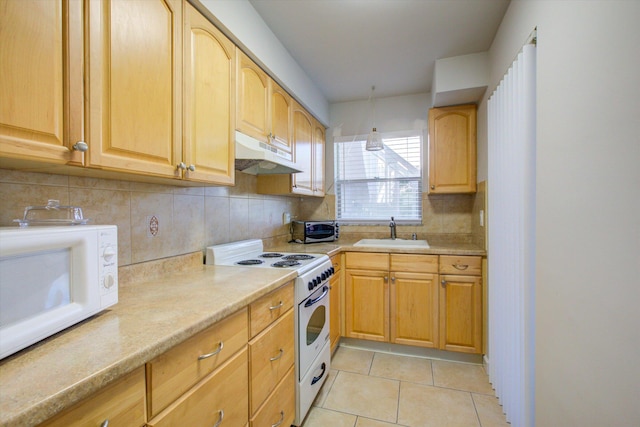 kitchen featuring tasteful backsplash, sink, light tile patterned floors, and white appliances