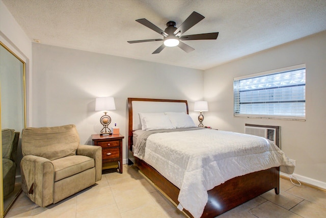 bedroom featuring light tile patterned floors, a textured ceiling, a wall unit AC, and ceiling fan