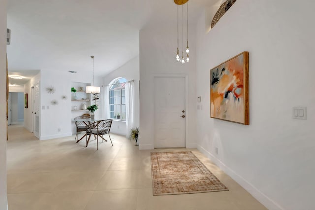 tiled entryway featuring an inviting chandelier