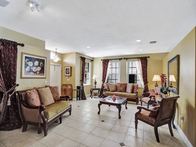 living room with a textured ceiling and light tile patterned floors