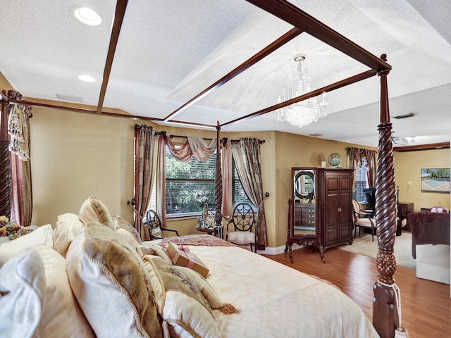 bedroom featuring a chandelier, a textured ceiling, and hardwood / wood-style flooring