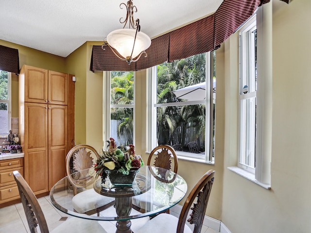 tiled dining area featuring a textured ceiling