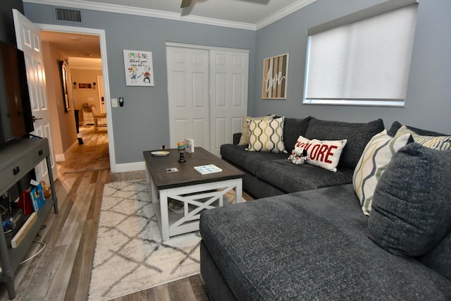 living room with hardwood / wood-style flooring and crown molding