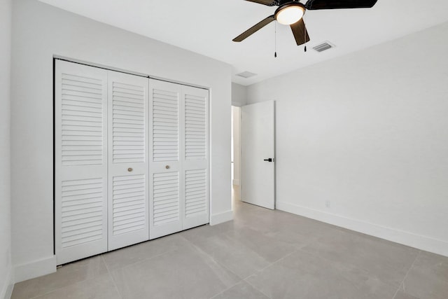 unfurnished bedroom featuring light tile patterned flooring, ceiling fan, and a closet