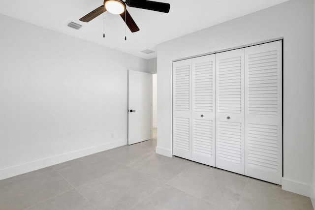 unfurnished bedroom featuring light tile patterned floors, ceiling fan, and a closet