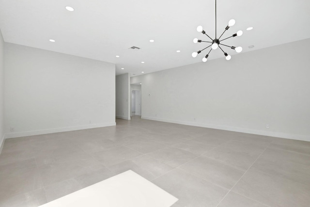 tiled spare room with a chandelier