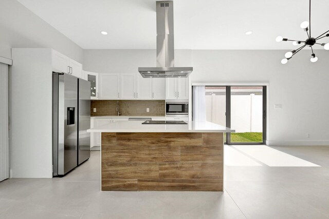 kitchen featuring white cabinets, stainless steel appliances, a center island, and island exhaust hood