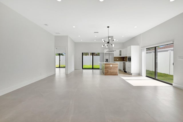 kitchen with a center island, white cabinets, a chandelier, pendant lighting, and appliances with stainless steel finishes