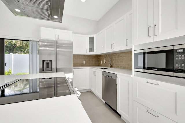 kitchen featuring decorative backsplash, white cabinets, sink, and stainless steel appliances