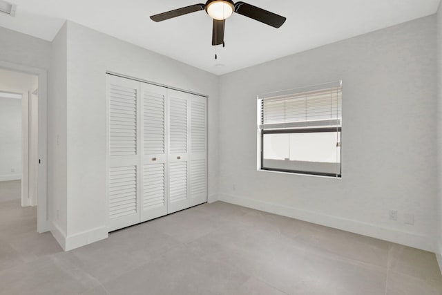 unfurnished bedroom featuring ceiling fan and a closet