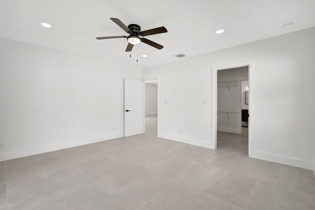 unfurnished bedroom featuring a closet, a spacious closet, and ceiling fan