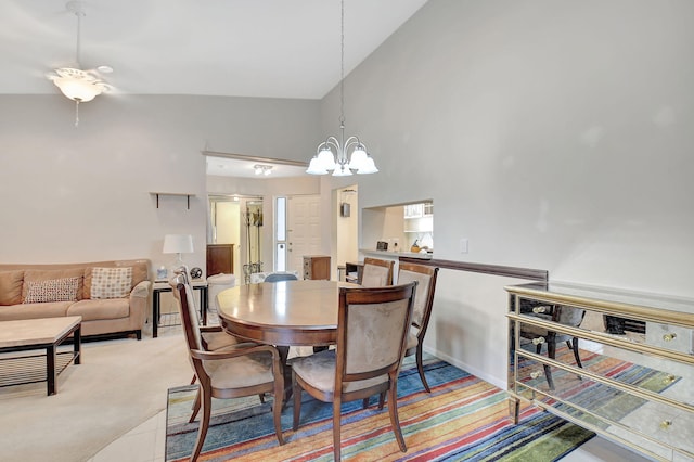 dining room with carpet floors, high vaulted ceiling, and an inviting chandelier