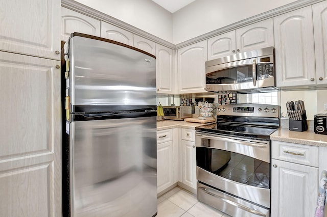 kitchen with appliances with stainless steel finishes and light tile patterned floors