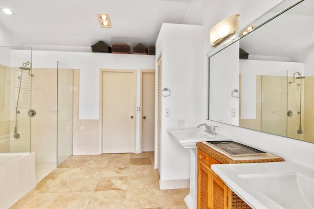 bathroom featuring dual sinks and a tile shower