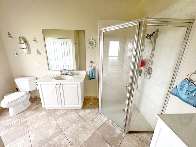 bathroom with tile patterned flooring, vanity, a shower with shower door, and toilet