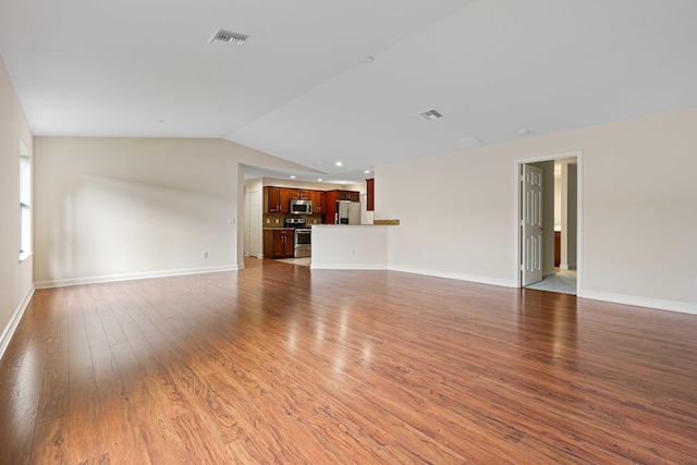 unfurnished living room featuring wood-type flooring and lofted ceiling