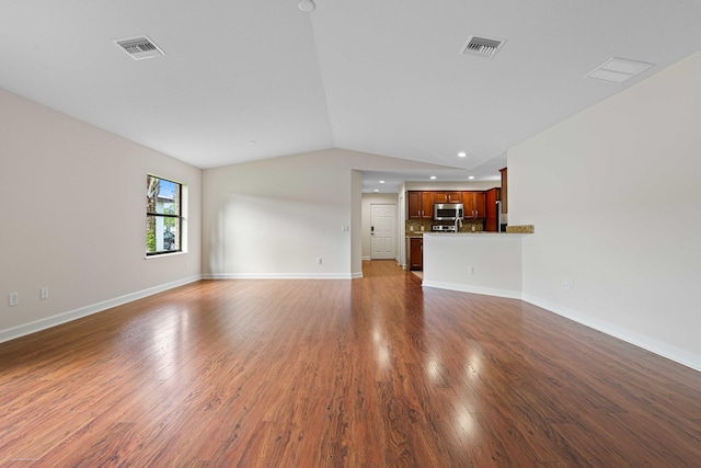 unfurnished living room with dark wood-type flooring and lofted ceiling